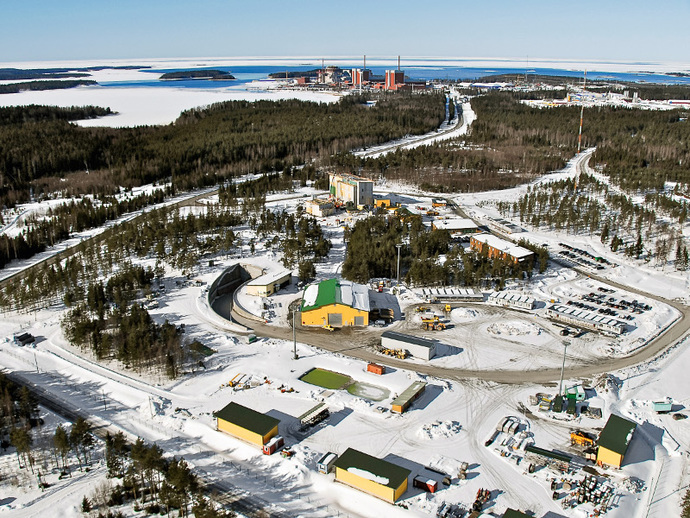 Ein Blick aus der Luft auf die übertägigen Anlagen des finnischen Endlagers Onkalo. Im Hintergrund sieht man das Kernkraftwerk Olkiluoto.