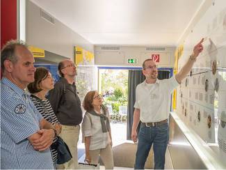 Ein BASE-Mitarbeiter gibt einer Besuchergruppe an einer Wandtafel einen Überblick zu 60 Jahren Kernenergienutzung und Endlagersuche in Deutschland (Bild anzeigen)