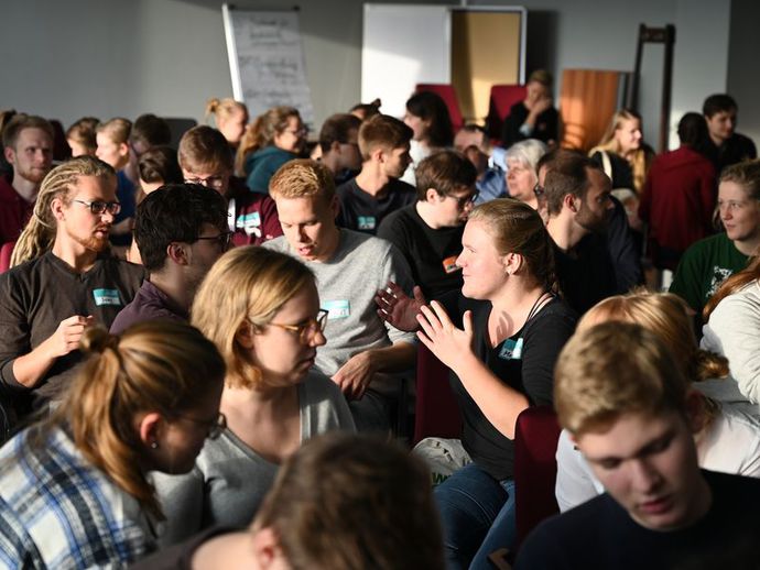 Eine Gruppe junger Menschen diskutieren über Beteiligung