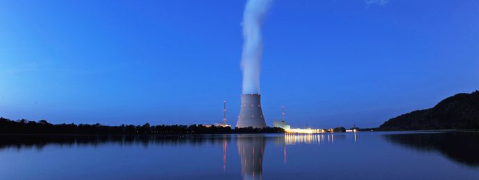 Water vapour rises from the cooling tower of a nuclear power plant into the evening sky